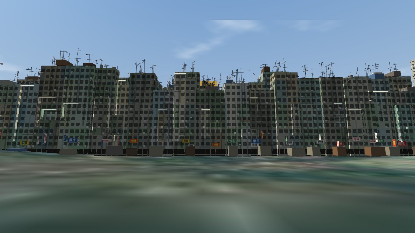 The south wall of the Walled City from street level: a cliff of balconies and windows with TV aerials along the roofline and small shop signs at the foot.