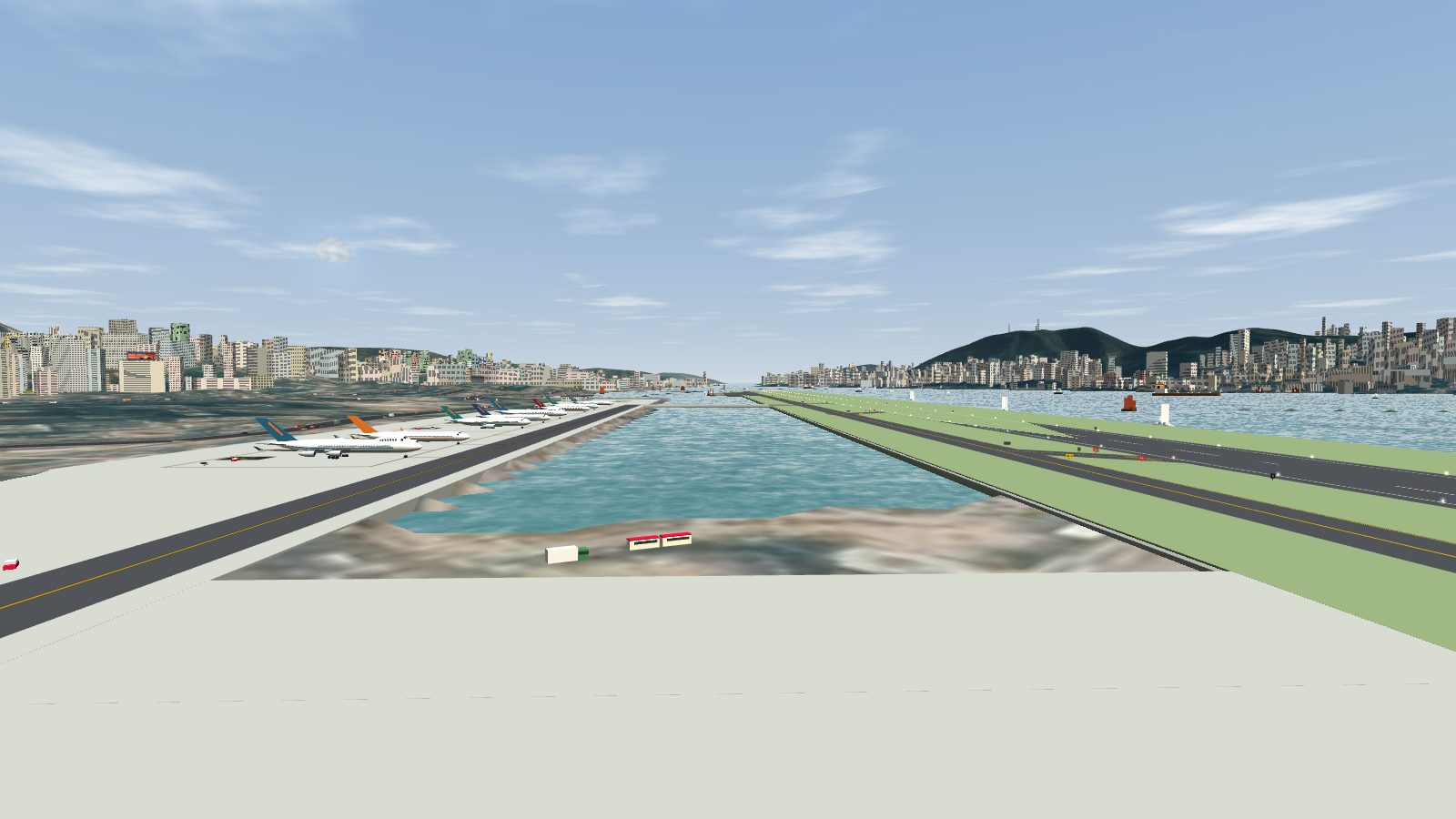 The water inlet between the runway-side taxiway and the south apron, empty, with boats out in the harbour beyond.